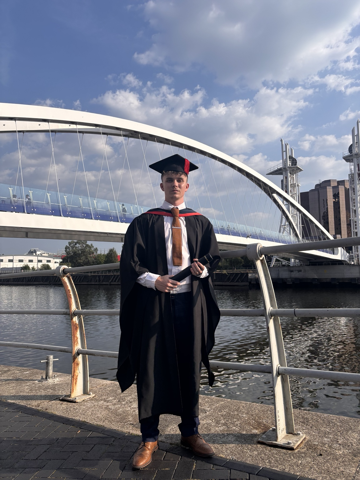 Ethan Conroy on his graduation day, holding his Sports Rehabilitation degree