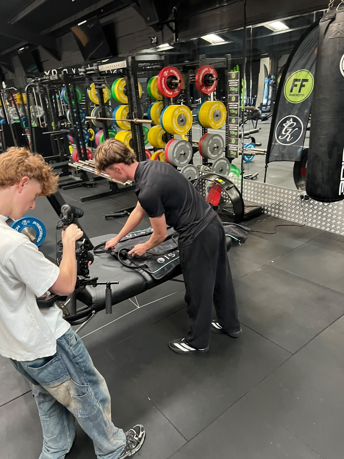 Ethan working with compression recovery boots while being filmed in the gym
